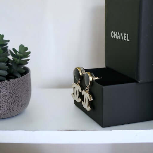 Chanel New Gold Black & White Double C Dangle Post EarringsExperience the latest trend with these Chanel New Gold Black & White Double C Dangle Post Earrings. The sophisticated black post earrings are complemented by the elegant and minimalistic white dou