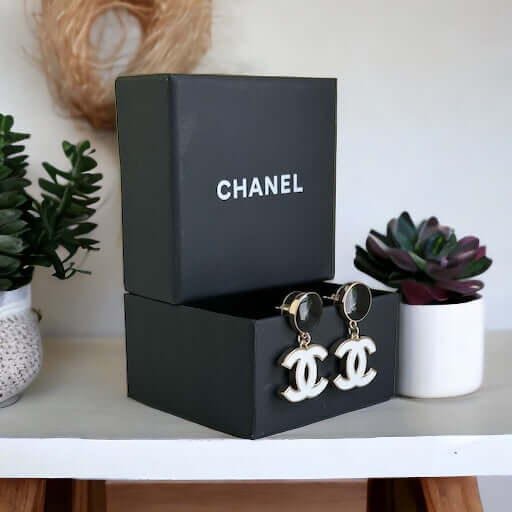 Chanel New Gold Black & White Double C Dangle Post EarringsExperience the latest trend with these Chanel New Gold Black & White Double C Dangle Post Earrings. The sophisticated black post earrings are complemented by the elegant and minimalistic white dou