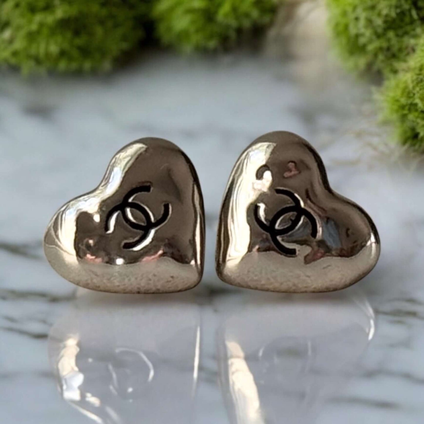 Authentic Chanel gold plated heart earrings with black enamel CC logo, pre-owned in excellent condition.