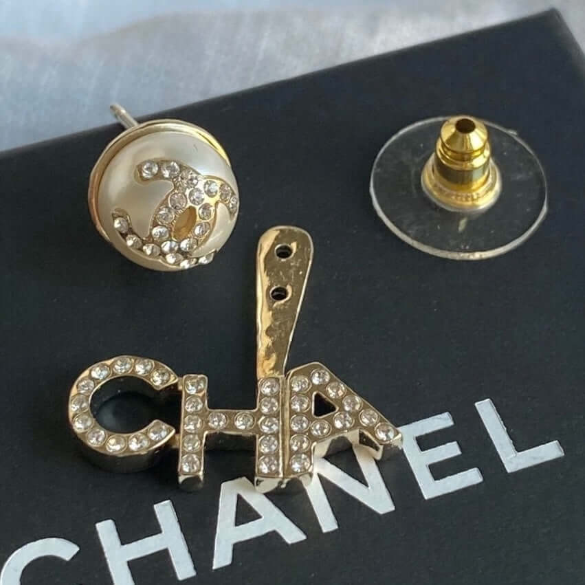 Chanel Gold CC Crystals Enamel Drop Earrings with "CHA" and crystal-encrusted CC center, on black box with authentic Chanel branding.