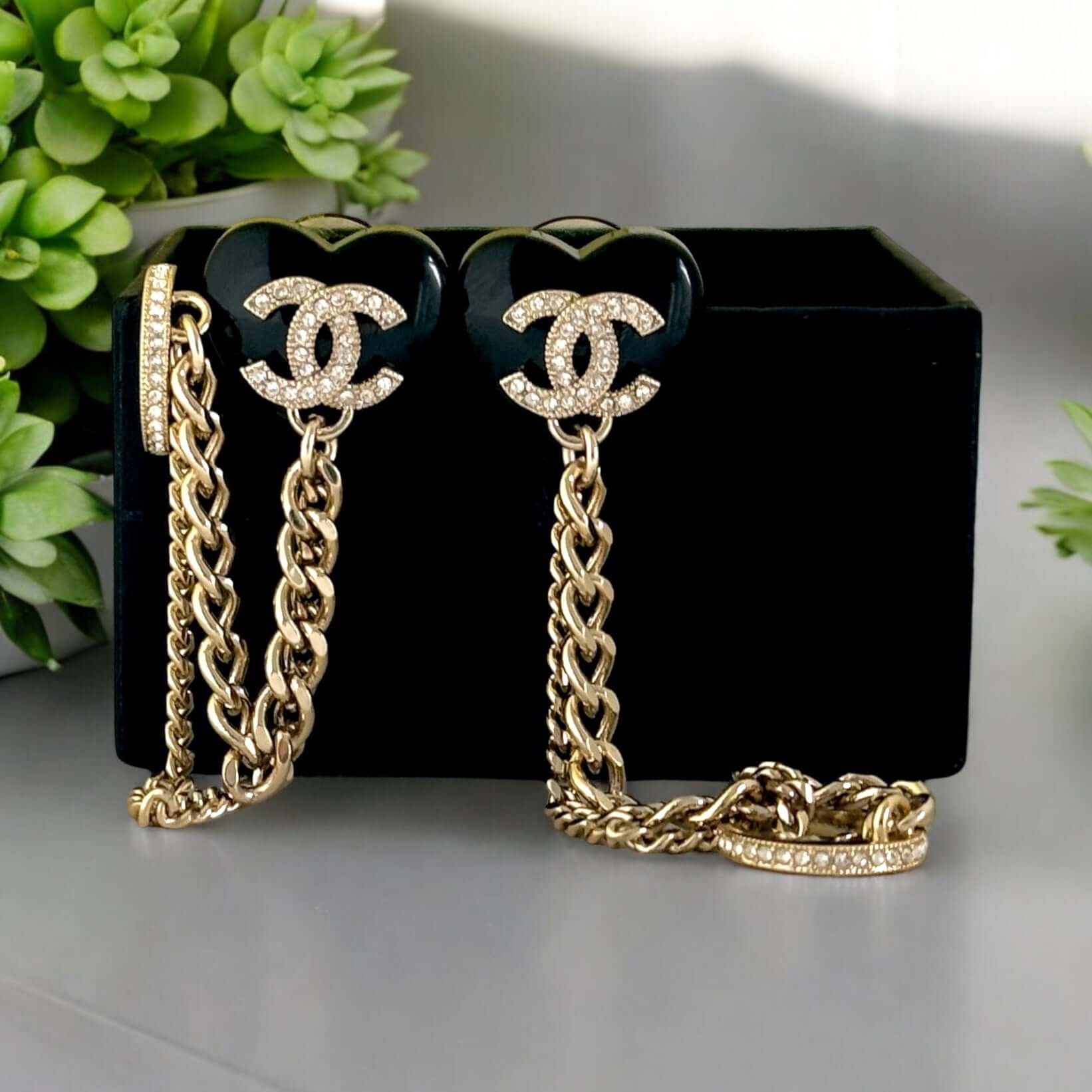 Chanel CC gold and black chain heart earrings with attached ear cuff; adorned with crystals, floral design, and black enamel petals.