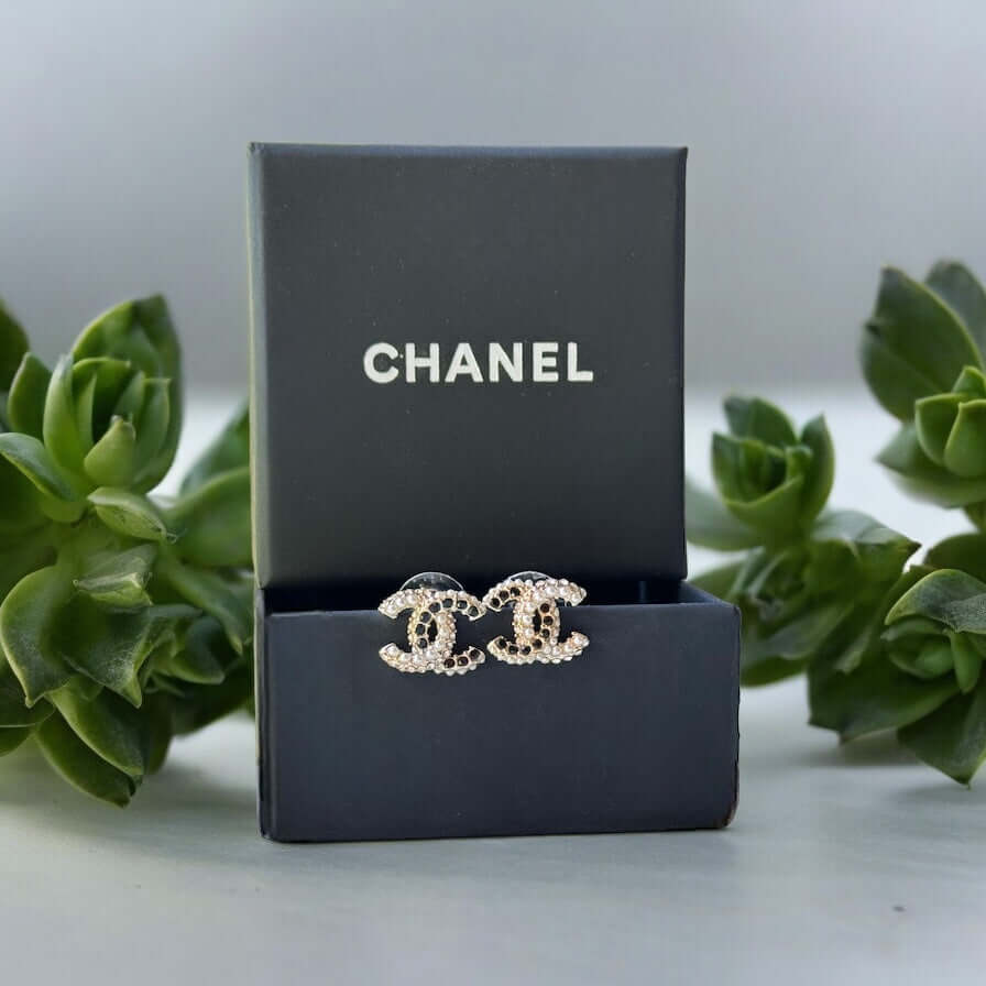 Chanel CC Gold Setting with Mini Pearls & Black Crystals Made In Italy"Add a touch of quirky luxury to your look with Chanel CC Gold Setting earrings. Smaller in size, but big in style, these post earrings feature a mixture of mini pearls and black crysta