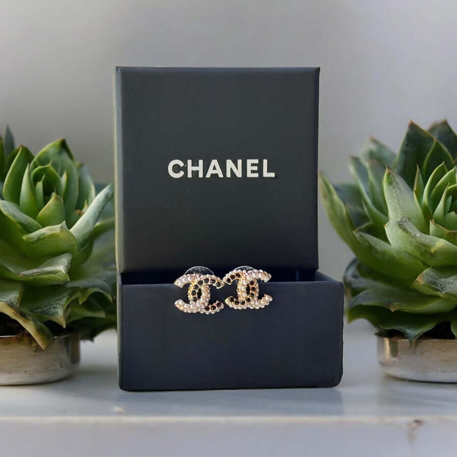 Chanel CC Gold Setting with Mini Pearls & Black Crystals Made In Italy"Add a touch of quirky luxury to your look with Chanel CC Gold Setting earrings. Smaller in size, but big in style, these post earrings feature a mixture of mini pearls and black crysta