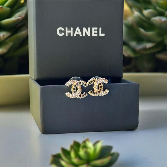 Chanel CC Gold Setting with Mini Pearls & Black Crystals Made In Italy"Add a touch of quirky luxury to your look with Chanel CC Gold Setting earrings. Smaller in size, but big in style, these post earrings feature a mixture of mini pearls and black crysta