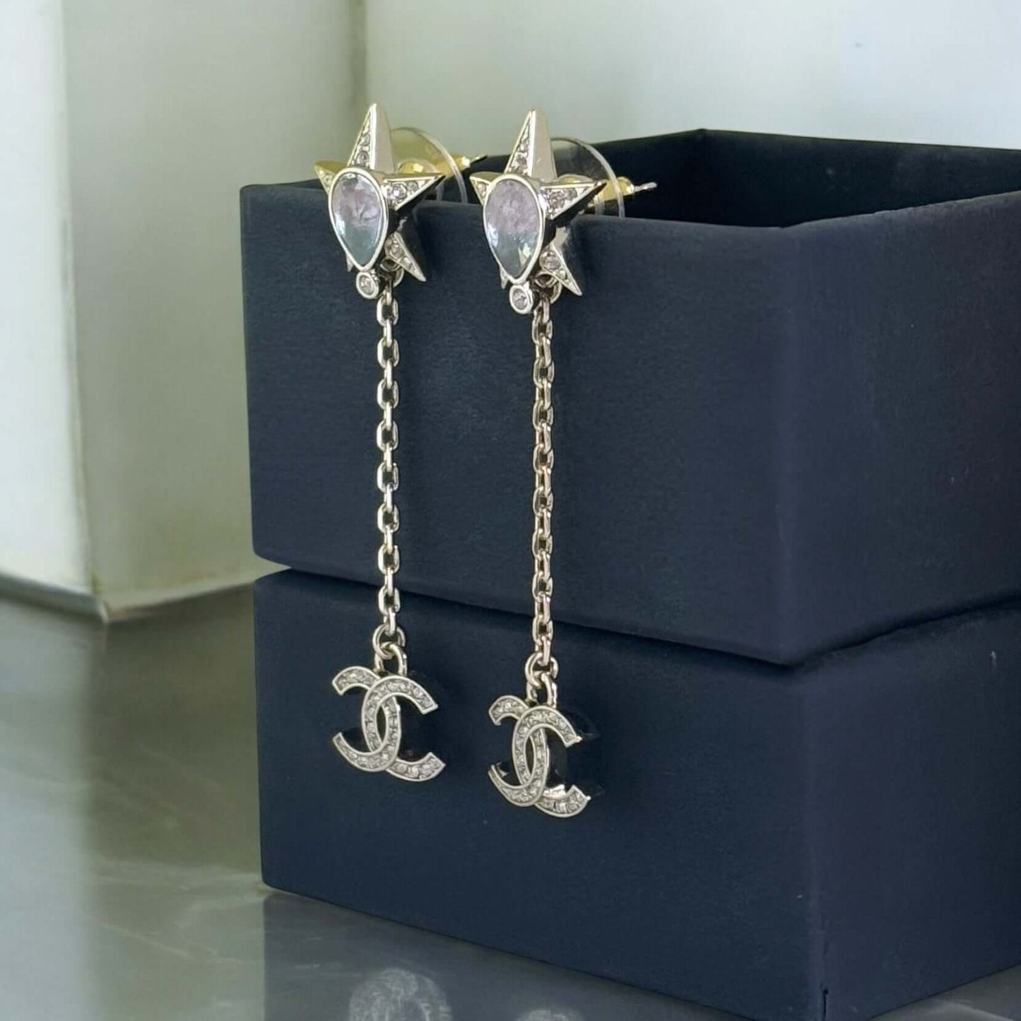 Gorgeous pre-owned Chanel CC star dangle earrings with colorful crystals, featuring a chain drop design in excellent condition.