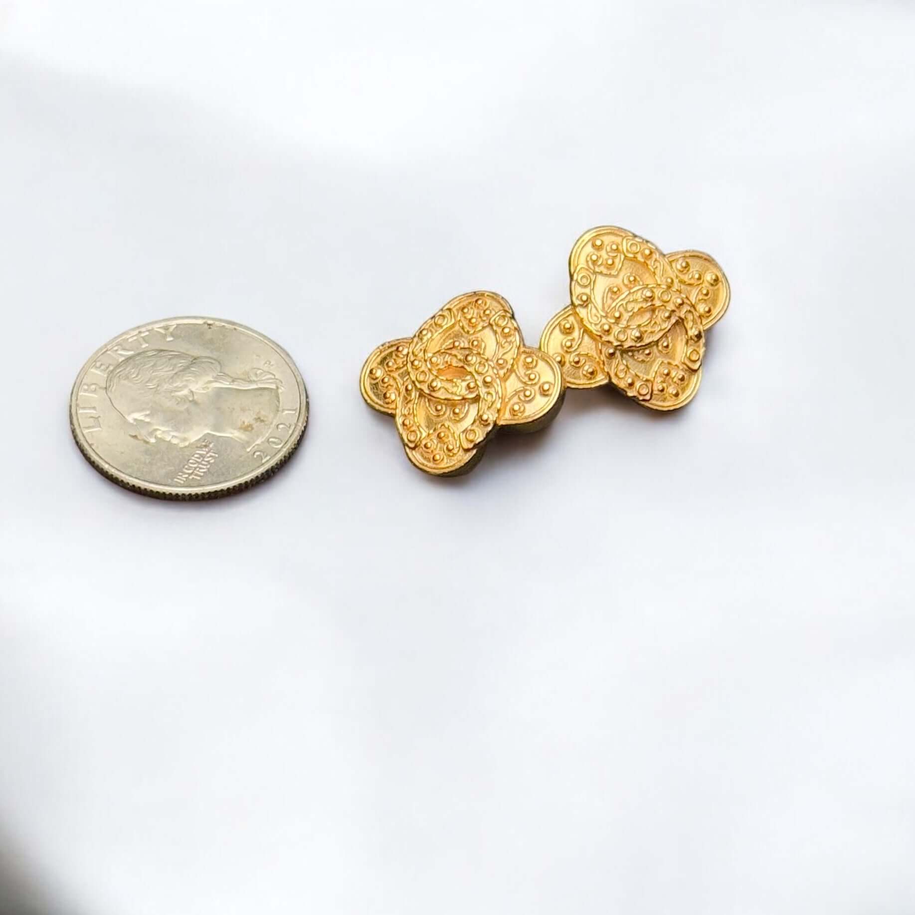 Vintage Chanel Gold Baroque CC Clip On Earrings beside a coin for size reference, pre-owned in good clean condition.