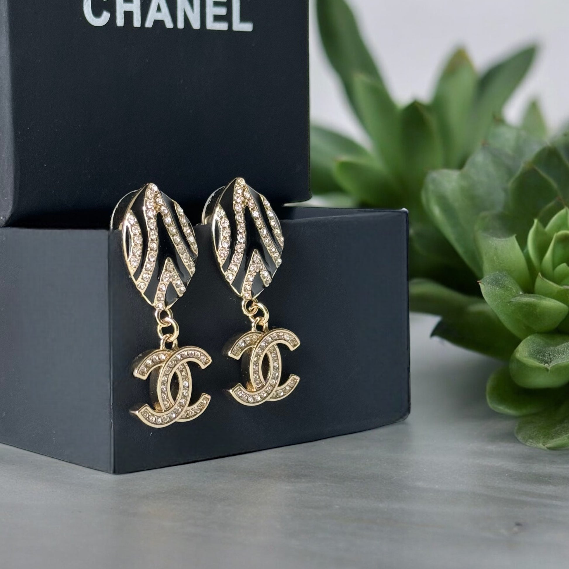 Chanel Gold Plated & Black Enamel & Crystals Oval Shaped Double C Dangling Post EarringsTake a bold step with these Chanel Gold Plated & Black Enamel & Crystals Oval Shaped Double C Dangling Post Earrings. The on-trend zebra-like design is perfect for ris