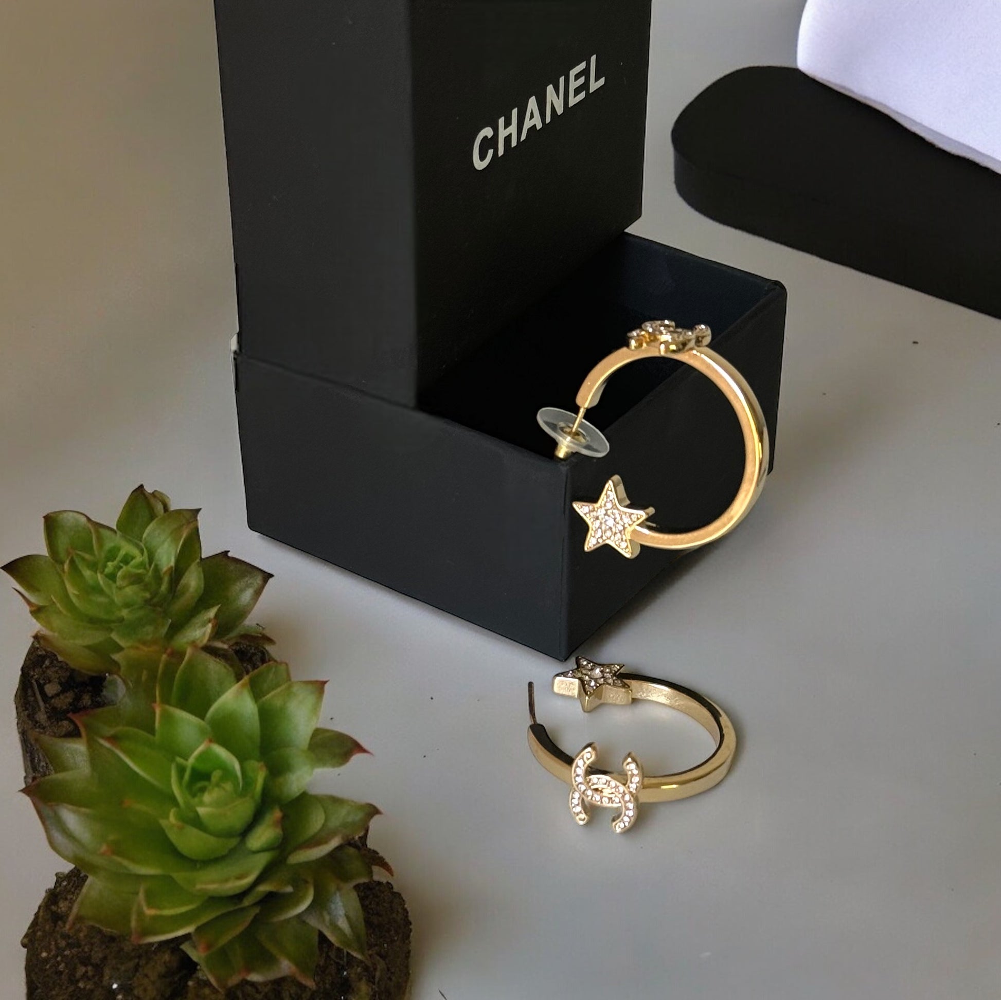 Chanel Strass Medium Sized Double C accented with Crystals with Blinged Out Stars at the End Hoops"Upgrade your style with our Chanel Strass Medium Sized Double C hoops embellished with dazzling crystals and blinged out stars. These gold hoops are perfect