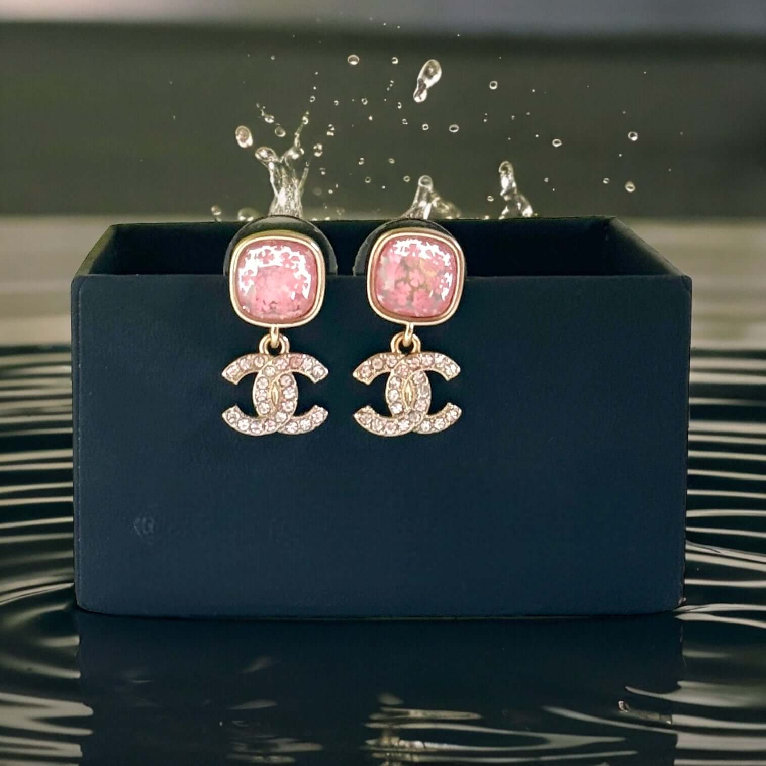 Add a touch of whimsy with these Chanel Strass CC Dangle Post Earrings. The stunning gold and pink design, featuring a mirror-like print and mini crystals, exudes playful charm. Upgrade your earring game with this current Chanel piece. These were a gift t