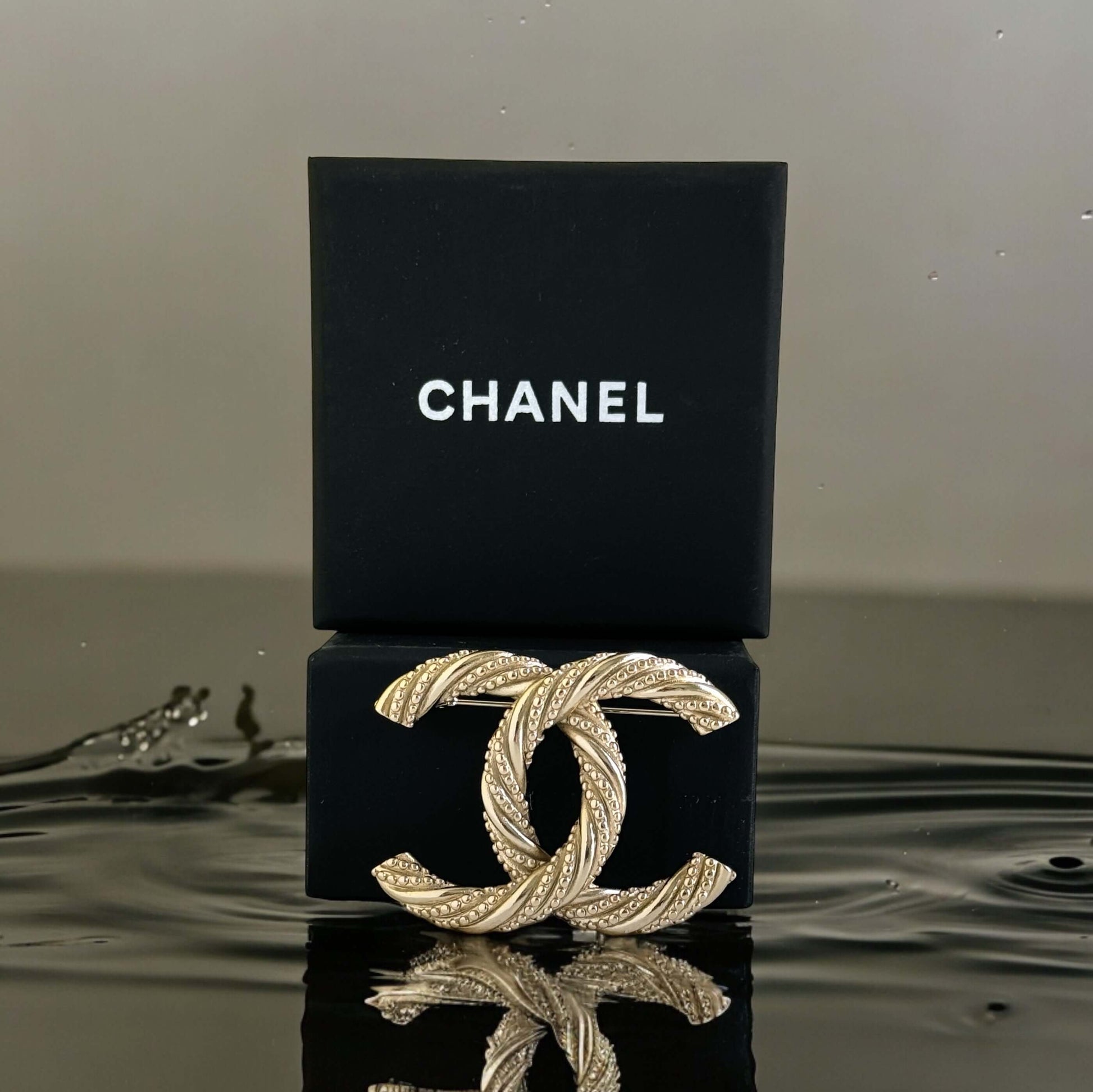 Add a touch of elegance and glamour to any outfit with the Chanel Gold Textured Twist CC Brooch Pin. Its twisted gold design and understated CC logo make it the perfect accessory for any occasion, all year round. Show off your sense of style with this mus