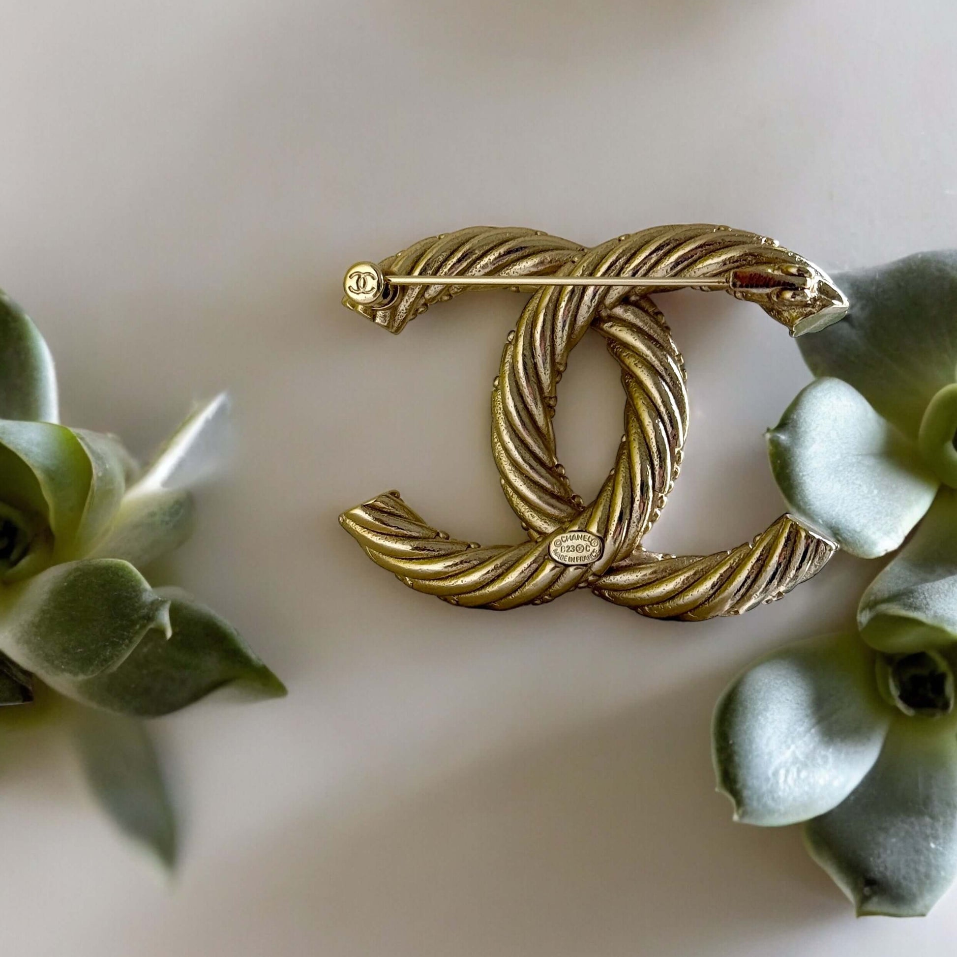 Add a touch of elegance and glamour to any outfit with the Chanel Gold Textured Twist CC Brooch Pin. Its twisted gold design and understated CC logo make it the perfect accessory for any occasion, all year round. Show off your sense of style with this mus