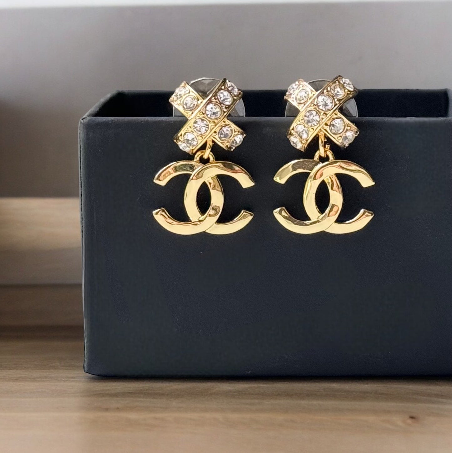 Chanel Gold Double C Dangle Earrings with Crystal Encrusted X’s Post EarringsAdd a touch of understated elegance to any outfit with Chanel's Gold Double C Dangle Earrings. Crystal encrusted X's add a statement touch to these comfortable post earrings. Per