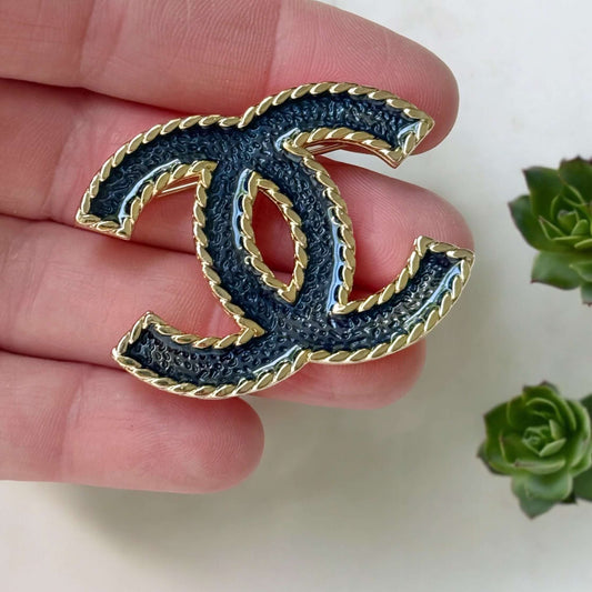 Chanel Lighter Gold Double C with Blue Denim Enamel Brooch Pin S24Experience the luxurious elegance of Chanel with our Lighter Gold Double C Brooch. This stunning brooch features a trendy denim blue enamel design and is ageless, making it perfect for any