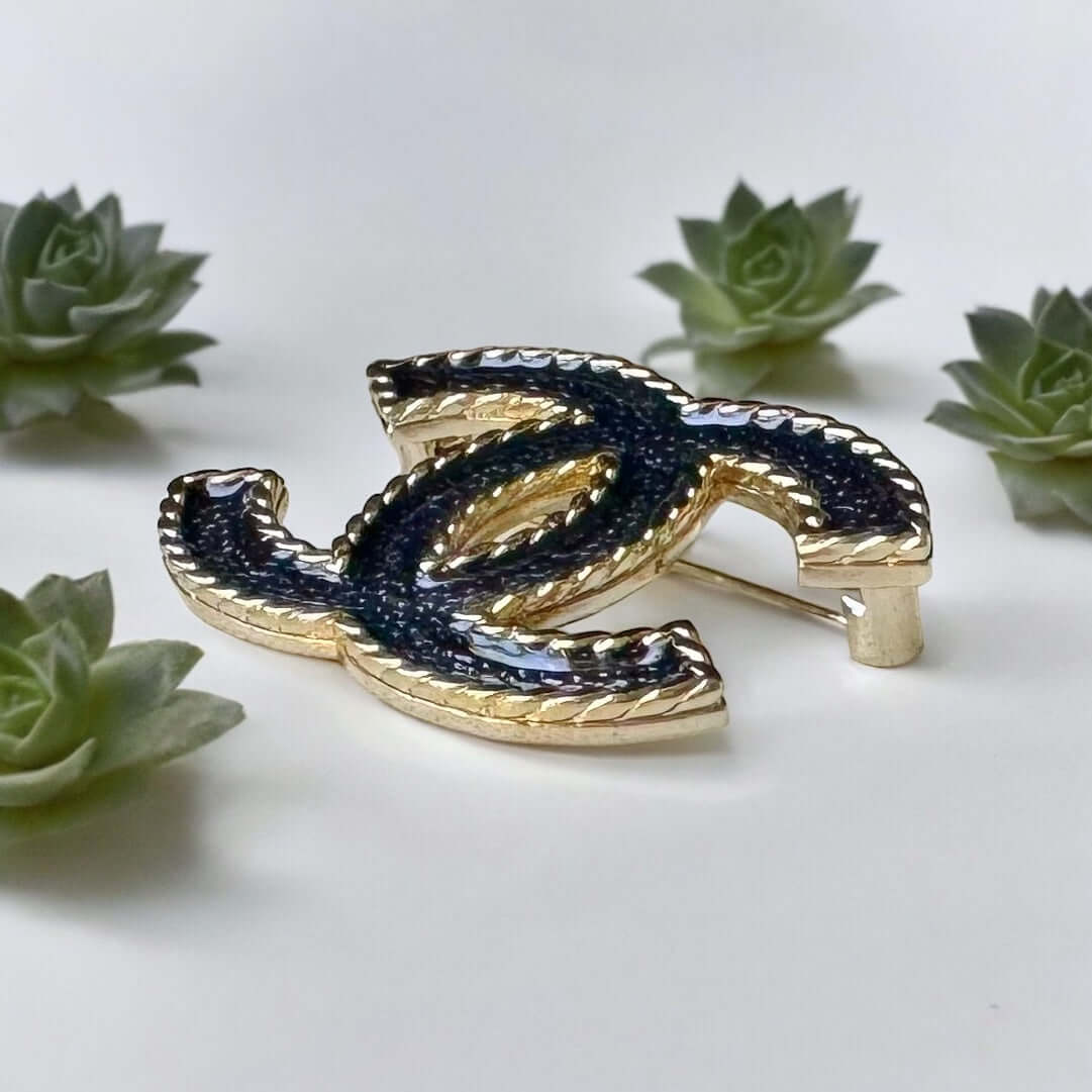 Chanel Lighter Gold Double C with Blue Denim Enamel Brooch Pin S24Experience the luxurious elegance of Chanel with our Lighter Gold Double C Brooch. This stunning brooch features a trendy denim blue enamel design and is ageless, making it perfect for any