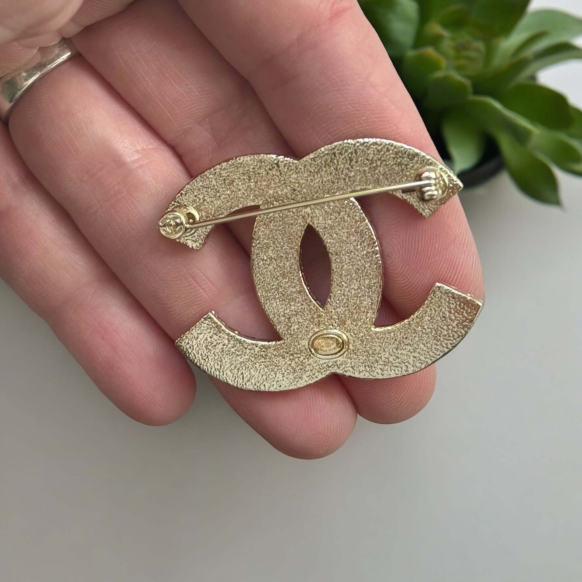 Chanel Lighter Gold Double C with Blue Denim Enamel Brooch Pin S24Experience the luxurious elegance of Chanel with our Lighter Gold Double C Brooch. This stunning brooch features a trendy denim blue enamel design and is ageless, making it perfect for any