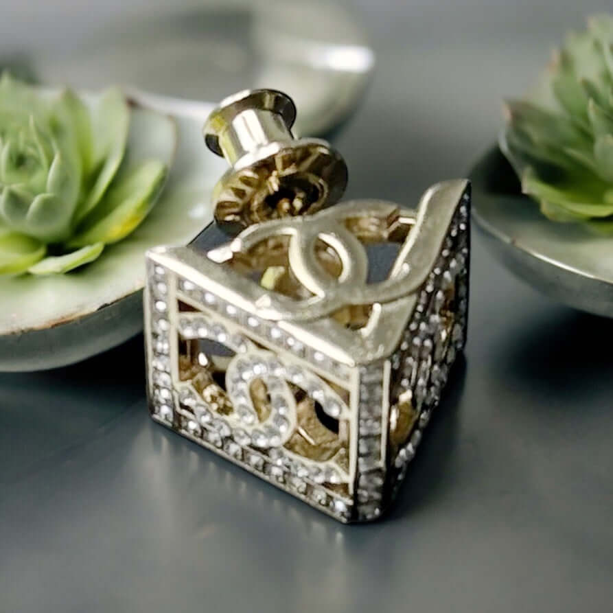 Chanel Lighter Gold Double C with Crystals Triangle Styled Smaller Brooch PinSet your style on fire with the Chanel Lighter Gold Double C brooch pin. Covered in dazzling crystals, this triangular piece adds a touch of bling to any outfit. Playfully chic,