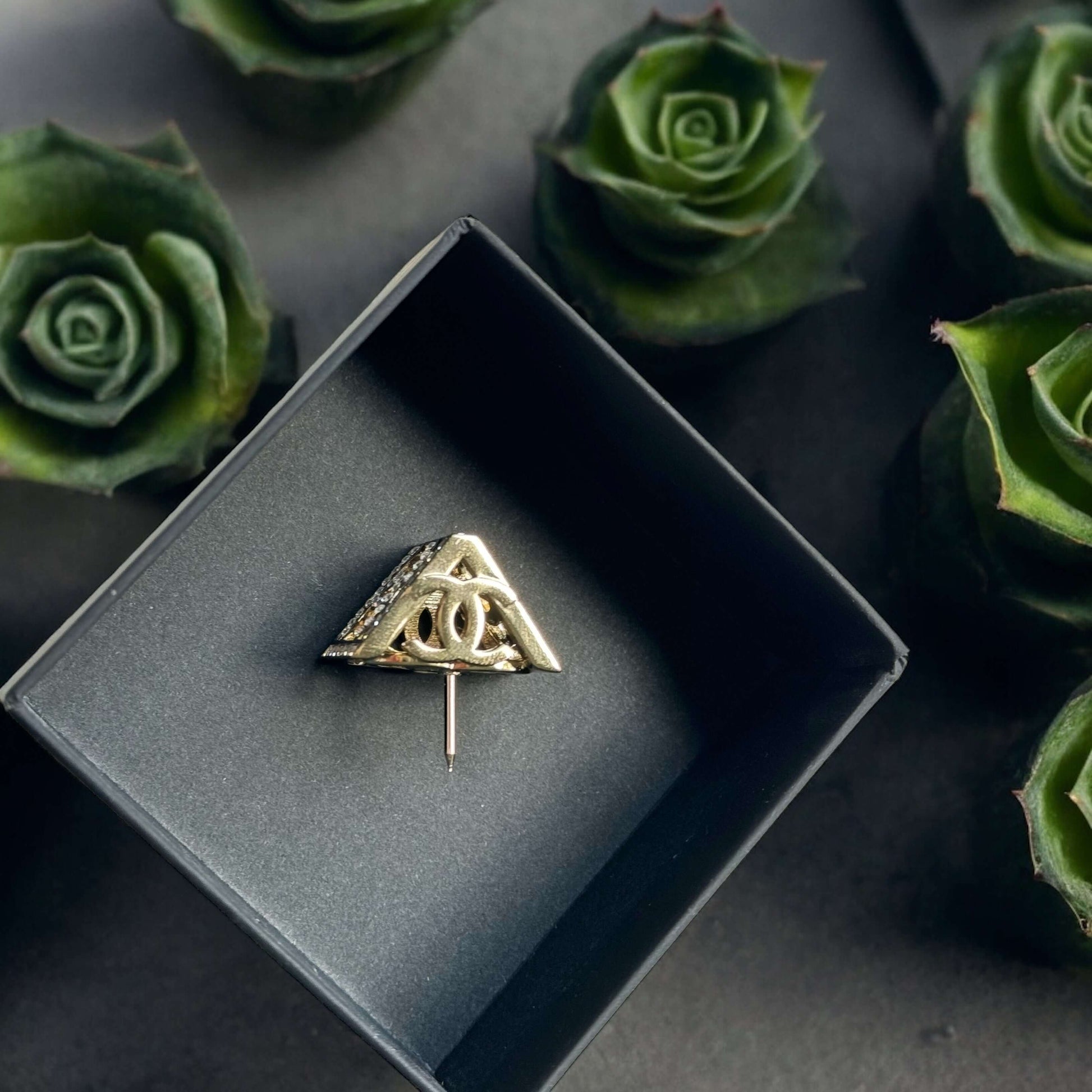 Chanel Lighter Gold Double C with Crystals Triangle Styled Smaller Brooch PinSet your style on fire with the Chanel Lighter Gold Double C brooch pin. Covered in dazzling crystals, this triangular piece adds a touch of bling to any outfit. Playfully chic,