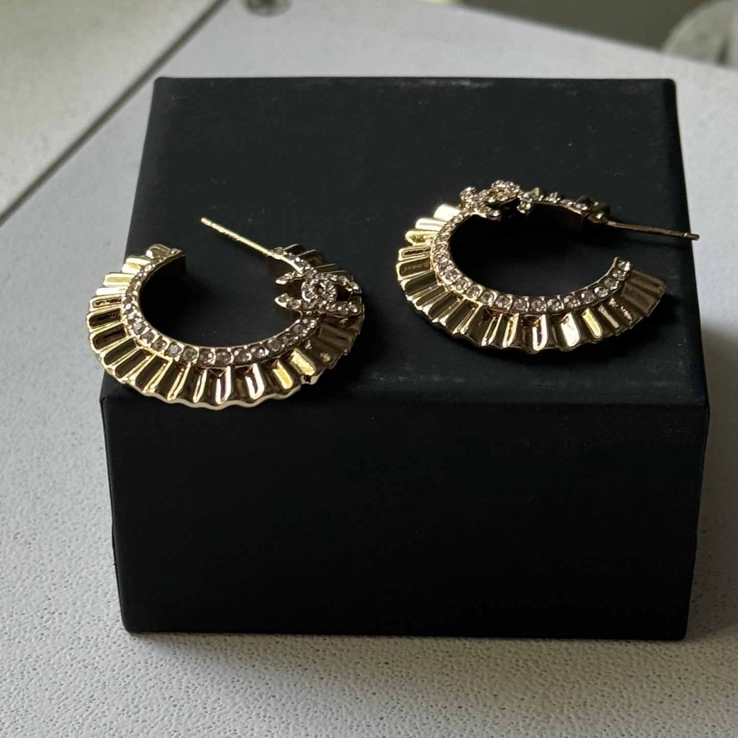 Gold Plated Chanel Flatten Hoops with Crystals Post EarringsStunning ! Gold Plated Bigger Hoops with great head turning texture with clear crystals accented along the inner side of these Double C Post Earrings Comes with the Chanel Box & Bag In clean grea