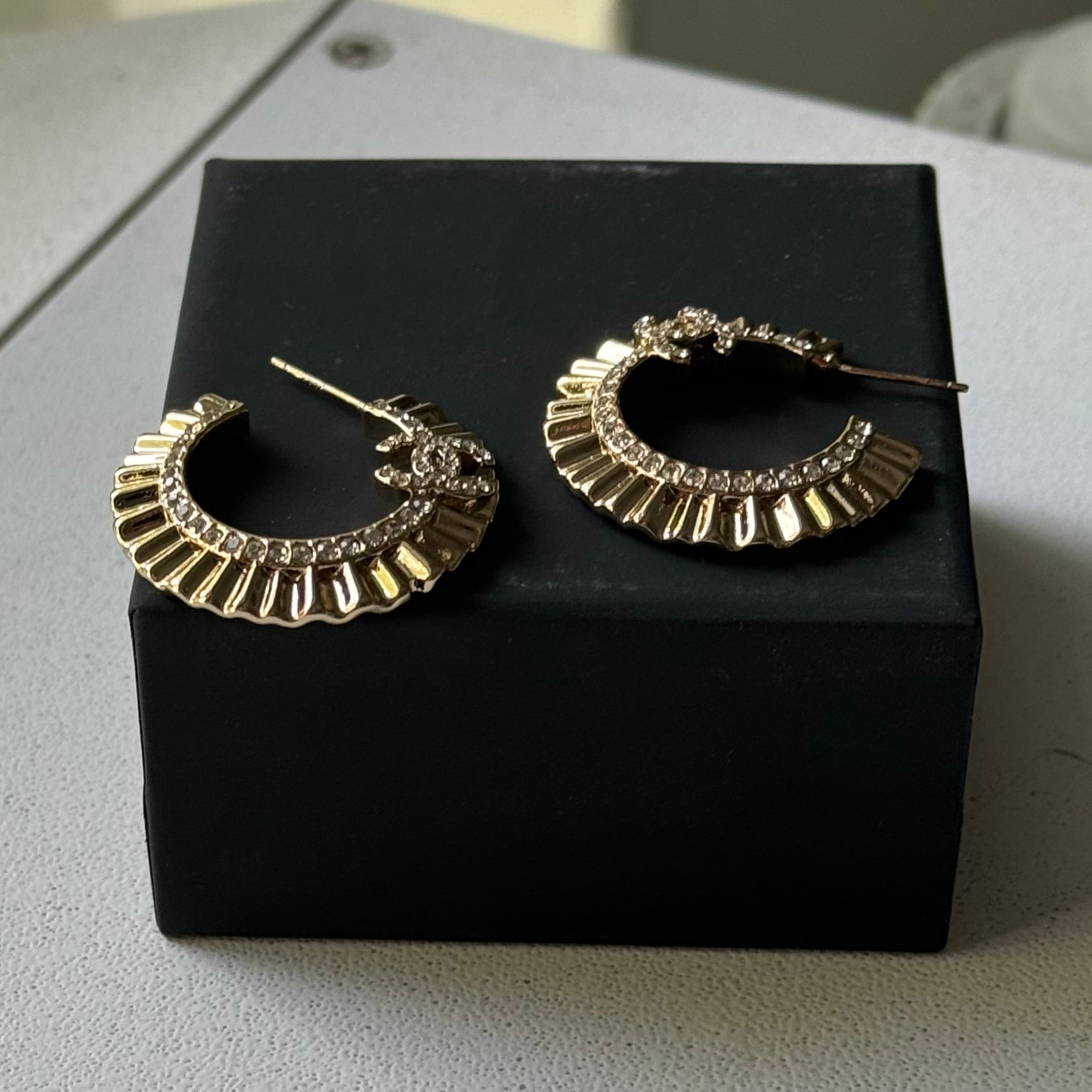 Gold Plated Chanel Flatten Hoops with Crystals Post EarringsStunning ! Gold Plated Bigger Hoops with great head turning texture with clear crystals accented along the inner side of these Double C Post Earrings Comes with the Chanel Box & Bag In clean grea