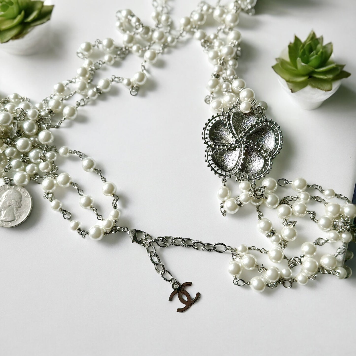 Chanel Pearl Camila Enamel Flower Three Strand NecklaceGorgeous Authentic Chanel Triple Strand (faux) Pearl linked with silver wiring , Double C with crystals Link , Black with silver accents enamel Camila Flower Focal Point Charm Lobster Safety Clasp Mar