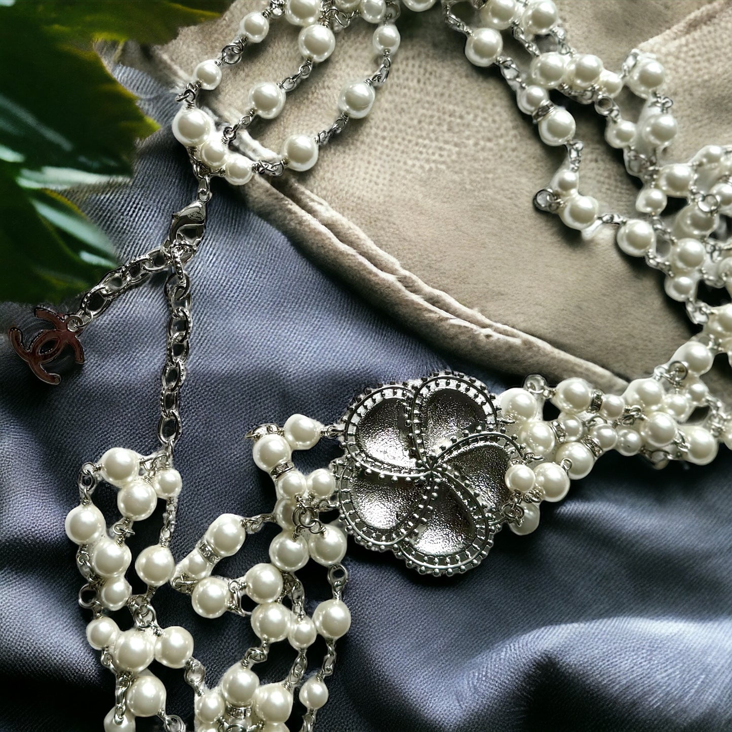 Chanel Pearl Camila Enamel Flower Three Strand NecklaceGorgeous Authentic Chanel Triple Strand (faux) Pearl linked with silver wiring , Double C with crystals Link , Black with silver accents enamel Camila Flower Focal Point Charm Lobster Safety Clasp Mar