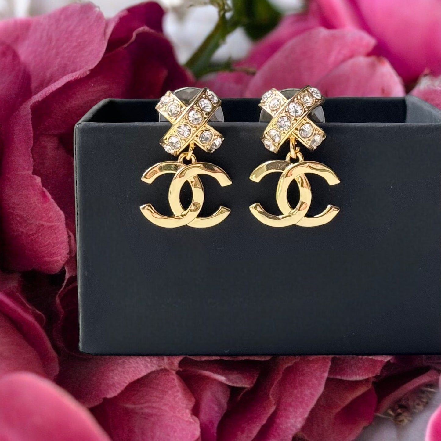 Chanel Gold Double C Dangle Earrings with Crystal Encrusted X’s Post EarringsAdd a touch of understated elegance to any outfit with Chanel's Gold Double C Dangle Earrings. Crystal encrusted X's add a statement touch to these comfortable post earrings. Per My Mama Found What 