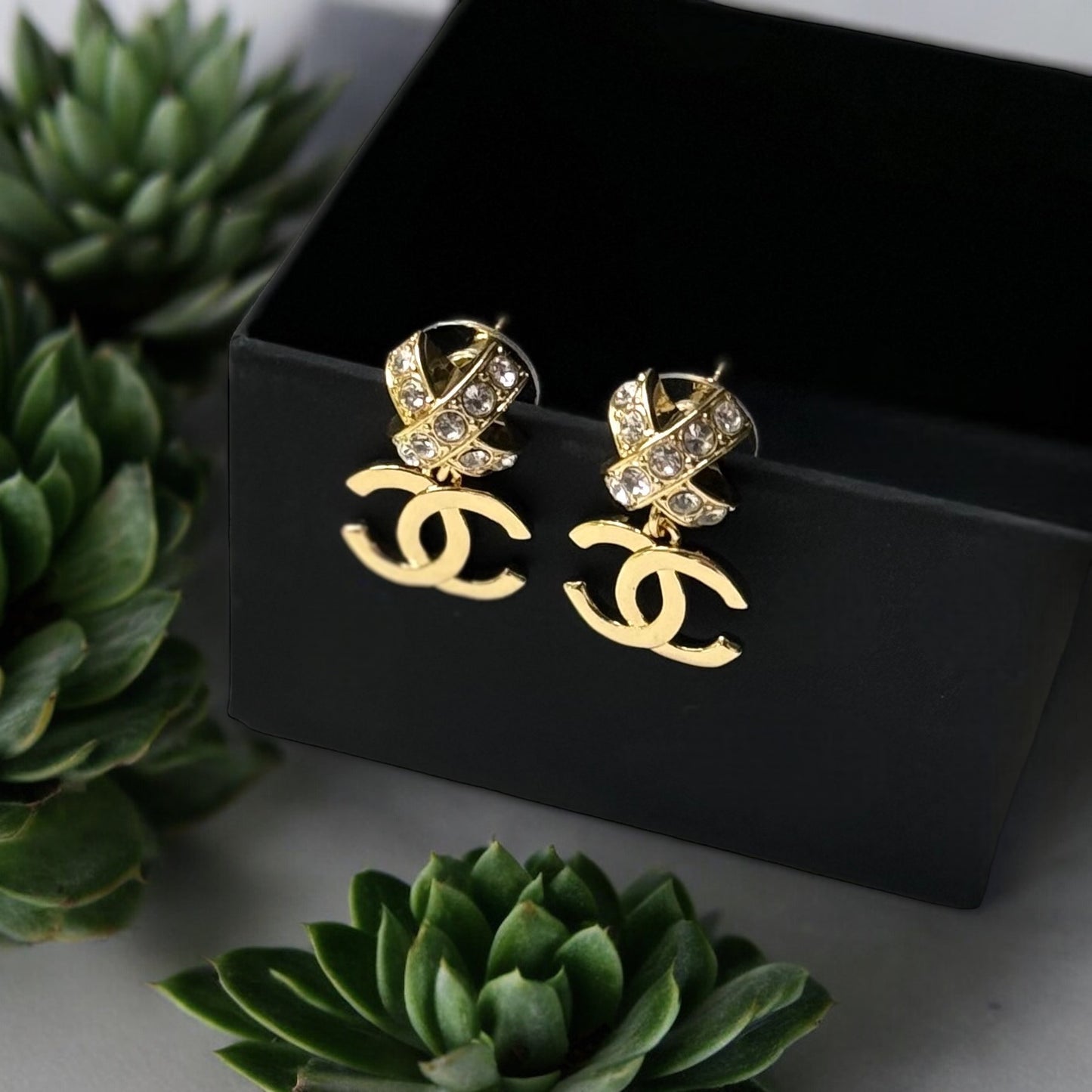 Chanel Gold Double C Dangle Earrings with Crystal Encrusted X’s Post EarringsAdd a touch of understated elegance to any outfit with Chanel's Gold Double C Dangle Earrings. Crystal encrusted X's add a statement touch to these comfortable post earrings. Per My Mama Found What 